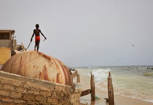 Uma criança brinca nas ruínas de um paredão