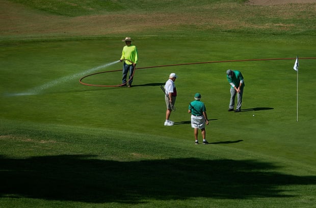 A ground guard waters the green at the fourth hole in California.