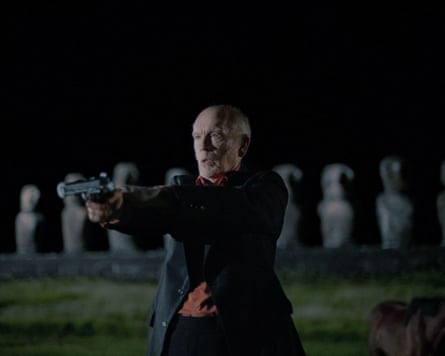 John holds a gun at night on Easter Island