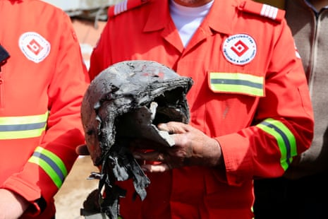A medic holds a destroyed helmet of one of the victims at the site of an airstrike in Habbariyah, southern Lebanon, on Wednesday.