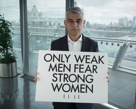 Khan holding a sign reading ‘Only weak men fear strong women’