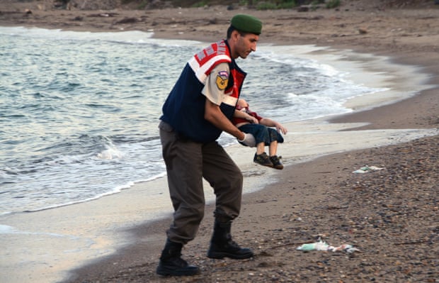 A police officer carries the lifeless body of Alan Kurdi