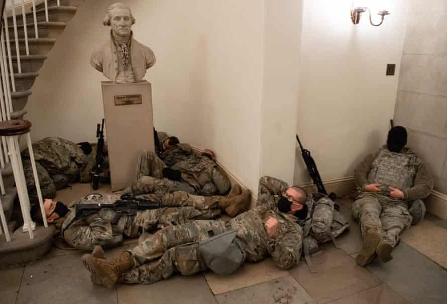 La Guardia Nacional descansa en la Rotonda del Capitolio de los Estados Unidos debajo de un busto de George Washington.