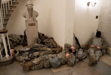 National Guard take a rest in the Rotunda of the US Capitol below a bust of George Washington.