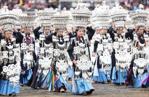 Women in traditional clothing including large headgear