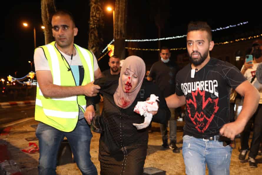 People help an injured Palestinian woman during a demonstration at Damascus Gate to support Palestinian families facing eviction from their homes in the Sheikh Jarrah neighborhood of Jerusalem.