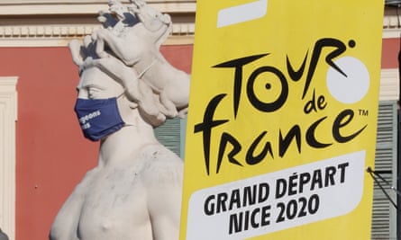 A Tour de France banner next to a statue with a protective face mask in Nice.