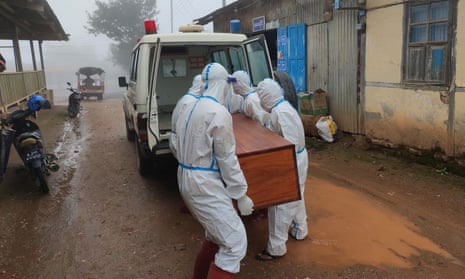 Workers in protective gear carrying a coffin bearing a body of a Covid-19 patient out of a hospital in Falam in western Myanmar.