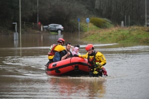 Rescue operations underway and a family is taken to safety, after flooding in Nantgarw, Wales.