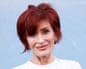 Sharon Osbourne in front of a light blue background
