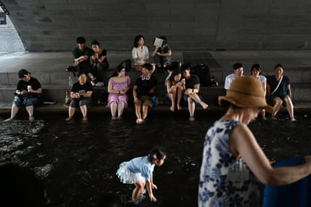 People cool off under a bridge over the Cheonggyecheon stream
