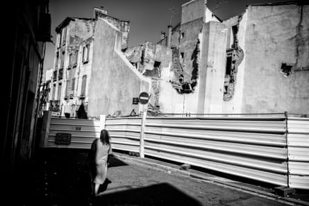 A woman walks past the steel sheets sealing off the Ilot Puig. The attempted destruction of this set of houses on a corner of the Place du Puig – a popular meeting point for the community – sparked protests against large-scale demolitions in St Jacques.