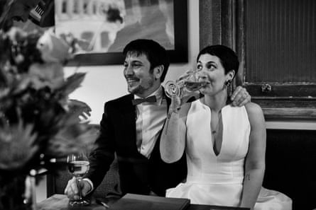 Black and white photo of a couple in wedding attire sitting at a table