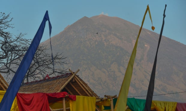 Mount Agung seen past huts at Amed beach: a diving instructor there said tourists had packed up and left.