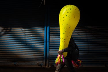 A large balloon is being carried through the street