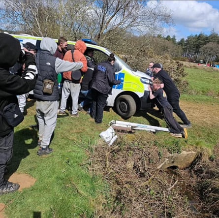 People push a police vehicle