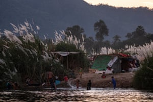 People are seen at a temporary camp by the river in Mae Sot, on the Thai-Myanmar border.