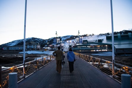 Two visitors walk on a boardwalk at the Perisher Centre at Perisher Blue Ski Resort