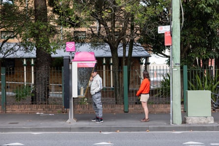 Caitlin Cassidy waits in line to use a payphone