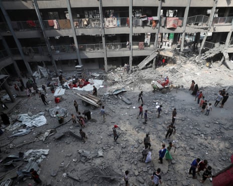 Palestinians inspect the damage at an UNRWA school sheltering displaced people that was hit in an Israeli air strike on Sunday, in Gaza City, June 30, 2025.