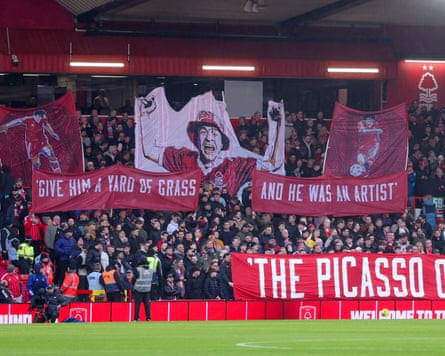 Fans hold up banners in tribute to the former Nottingham Forest player John Robertson, who died on Christmas Day