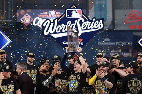 Cooper Pratt celebrates with the CommissionerâÂÂs Trophy after the Milwaukee Brewers defeated the Tampa Bay Rays 4-1 in Game 5 of the World Series to clinch the first championship in club history.