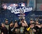 Cooper Pratt celebrates with the Commissioner’s Trophy after the Milwaukee Brewers defeated the Tampa Bay Rays 4-1 in Game 5 of the World Series to clinch the first championship in club history.