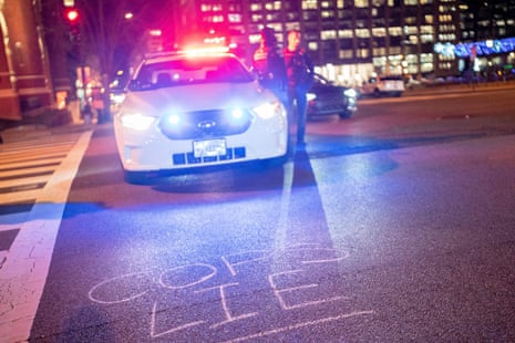 road says 'cops lie' in chalk in front of police car