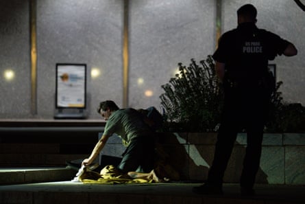Police remove a homeless man from the steps of the Smithsonian National Museum of American History on 14 August 2025 in Washington DC.