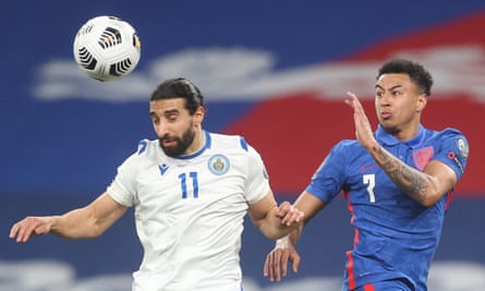 The San Marino defender Manuel Battistini heads the ball under pressure from the England midfielder Jesse Lingard.