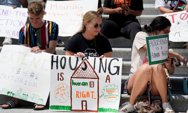 People hold signs supporting the eviction moratorium on the steps of the US Capitol on 31 July. 