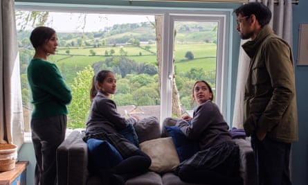 Pharmacist Faisal Bhatti with his family looking out window of house