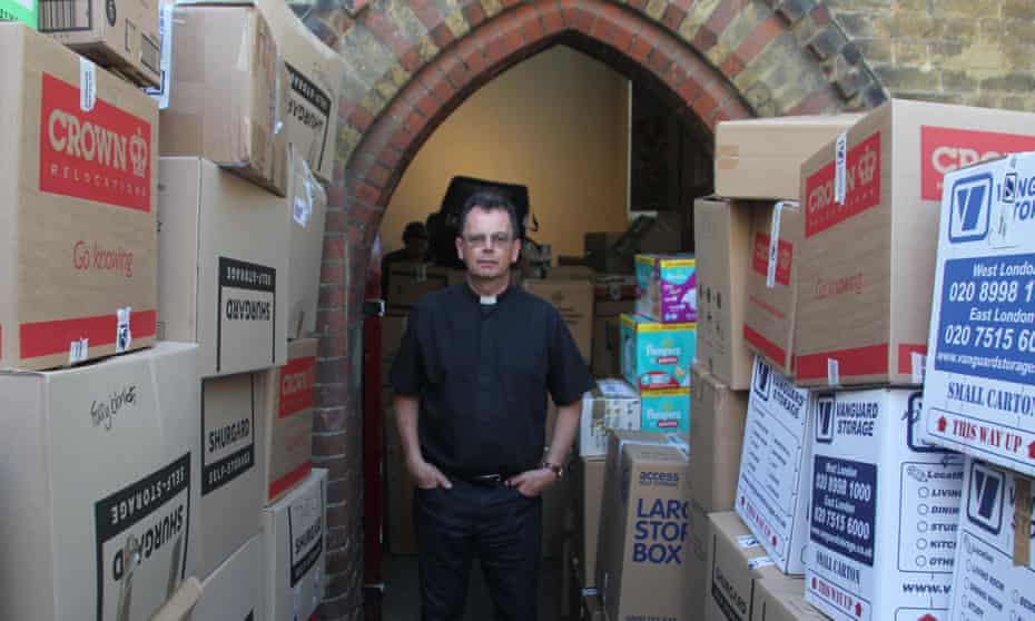 Rev Alan Everett surrounded by donations from the public at the church of St Clement’s, Notting Dale, next to Grenfell Tower