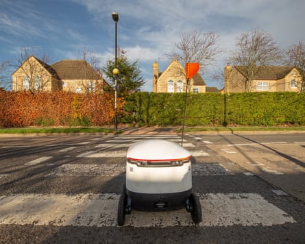 A Starship Technologies robot crosses a road during tests in Northampton, UK