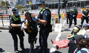Police remove a protester from the road during a climate protest in Melbourne on Saturday
