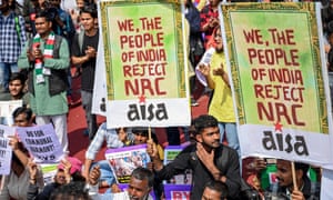Group of people, some holding a colourful sign saying "We the people of India reject NRC"