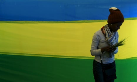 A woman walks past a Rwandan flag at a polling station. The county revised its penal code in 2018, restricting abortion to a narrow set of circumstances.