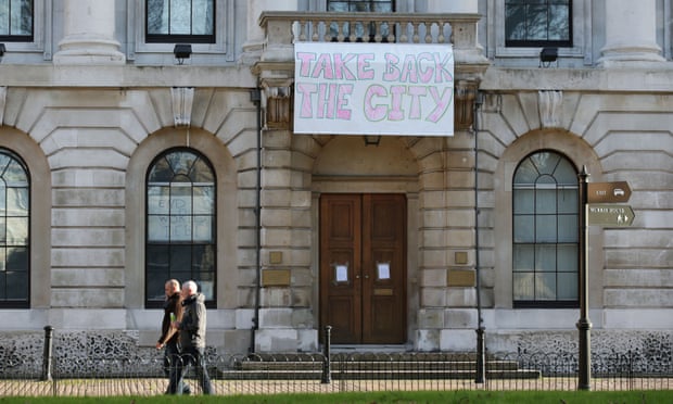 A sign hanging outside the Royal Mint building in Tower Hill saying: 'Take back the City'.