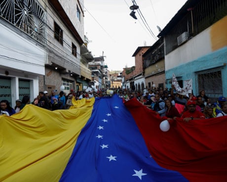 Protesters hold a giant Venezuelan flag
