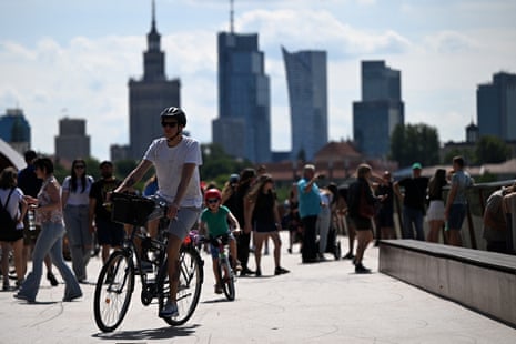 People cross a bridge as in background can be seen Warsaw’s skyscrapers including the Palace of Culture and Science (C-L) as Poles vote during the second round of the presidential elections.