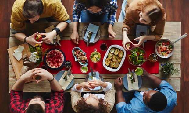 overhead view of six people around a table with dishes of food