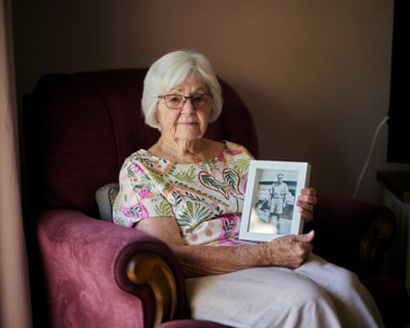 Wilma Spence seated in a chair, holding a framed photograph of her father. Albert Kemp served in the second world war and was buried at the Gaza War Cemetery, which has almost certainly been bulldozed by the IDF