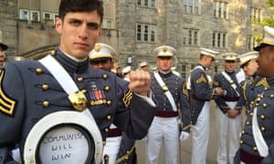 Spenser Rapone raises his left fist while displaying a sign inside his hat after graduating from the United States Military Academy at West Point.