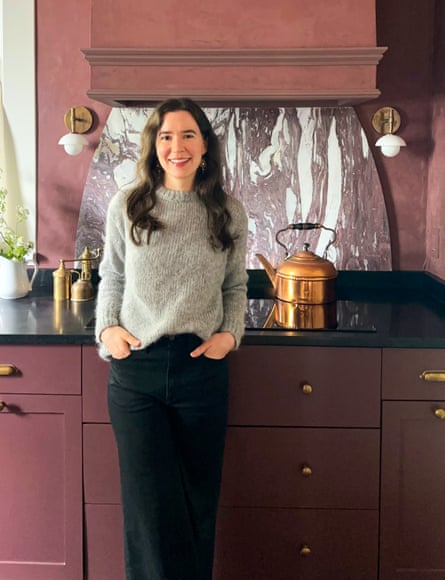 woman smiles in kitchen with hands in jeans pockets