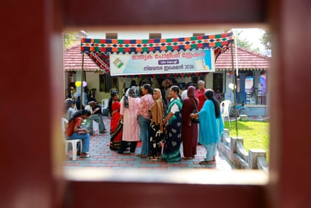 People stand in line to cast their votes at a polling station.