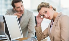 A man gesturing towards a female colleague, who is looking away from him and towards the camera