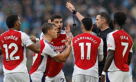 Leandro Trossard (second left) protests his innocence to the referee Michael Oliver during the Premier League match between Manchester City and Arsenal