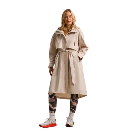 A woman models a long beige-coloured belted trenchcoat with a hood