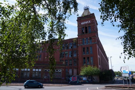 The derelict Warwick Mill, a redbrick building with a tall tower, in Middleton town centre
