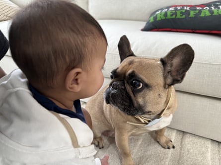 Walter, sitting on the floor, stares into the face of Paul’s young son